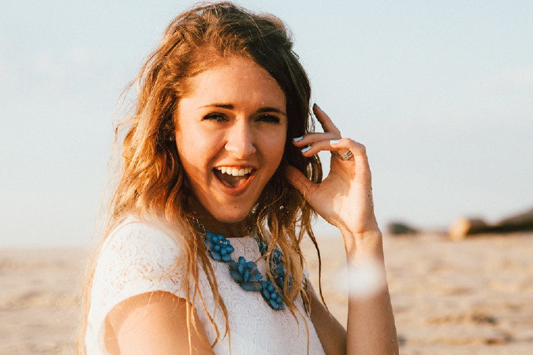 Kaitlyn laughing at Asbury Park Beach for Senior Photos during sunrise Kasey Ivan Photography
