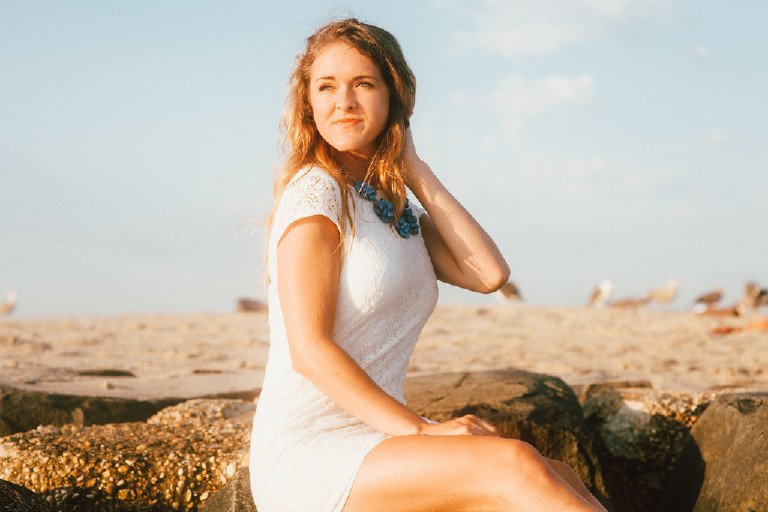 Kaitlyn smiling at Asbury Park Beach for unique Jersey Shore Senior Photos by Kasey Ivan Photography