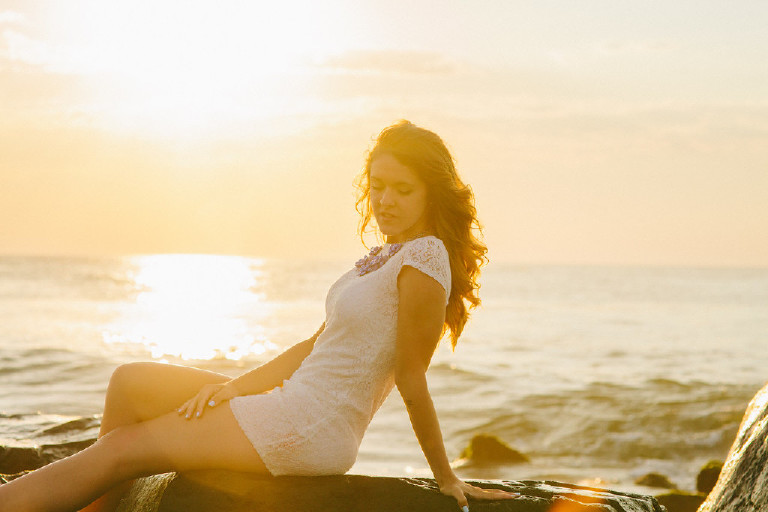 Kaitlyn reclining on rock at Asbury Park by Jersey Shore for Senior Photos with Kasey Ivan