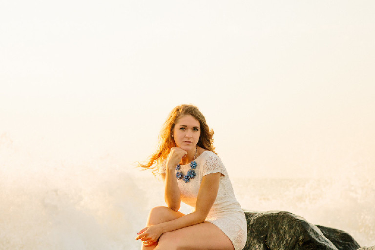 Kaitlyn at Asbury Park Beach for unique Senior Photos as waves splash during sunrise Kasey Ivan Photography