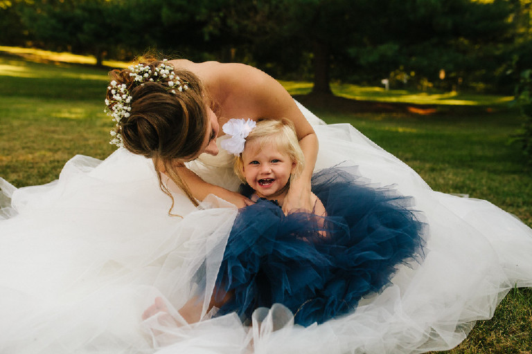 bride tickling flower girl in blue dress at Chimney Hill Estate wedding in Lambertville NJ