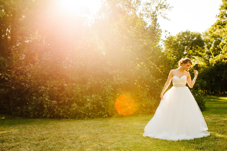 Kolbi the bride and lens flare photo in nature at Chimney Hill Estate wedding in Lambertville NJ