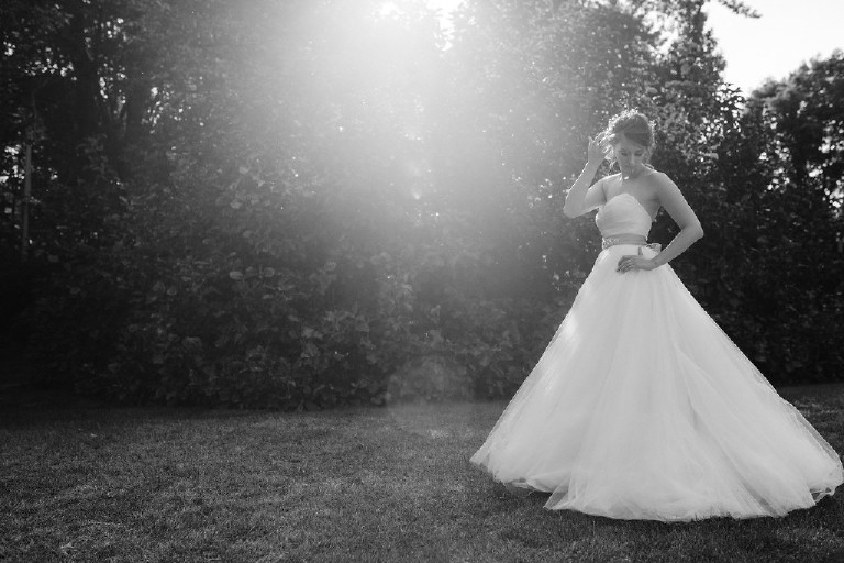 Kolbi the bride and black and white lens flare photo in nature at Chimney Hill Estate wedding in Lambertville NJ