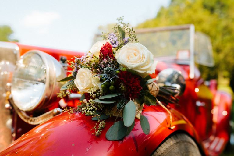 flower bouquet sitting on antique car at Chimney Hill Estate wedding in Lambertville