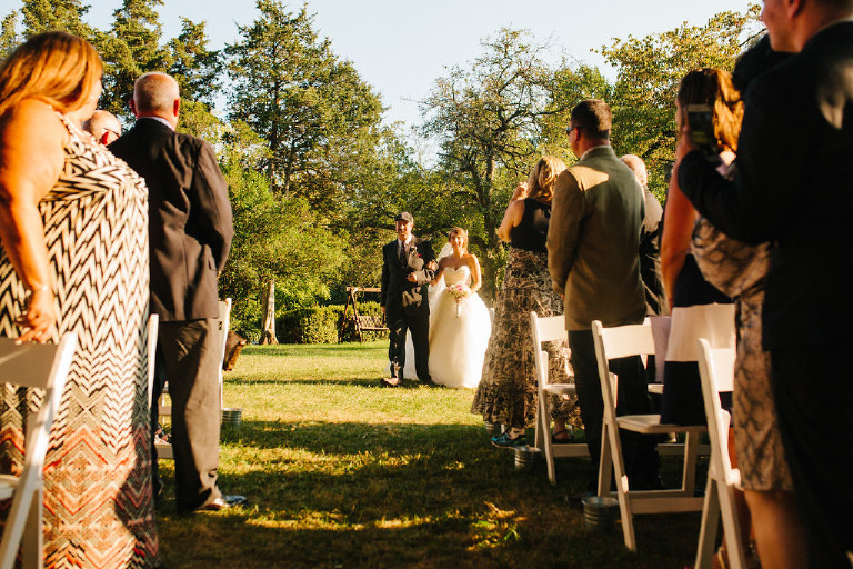 sun drenched bride walking down the aisle with father at Chimney Hill Estate wedding ceremony in Lambertville NJ