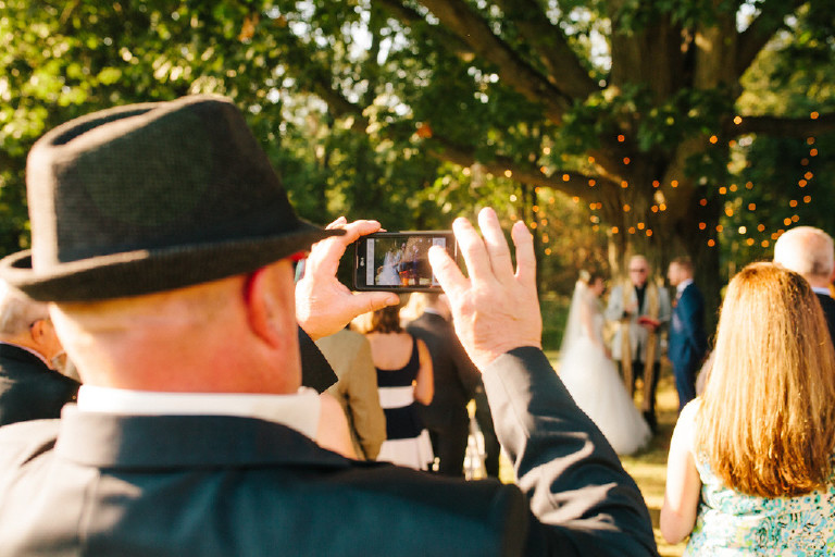 guest takes a photo at Chimney Hill Estate wedding ceremony in Lambertville NJ