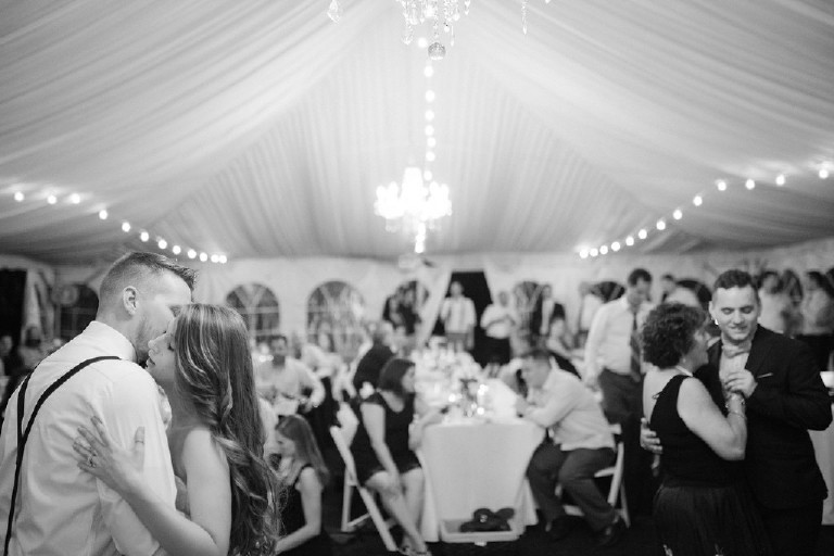 black and white bride and groom dancing with guests under canopy tent at Chimney Hill Estate wedding reception by Kasey Ivan Photography