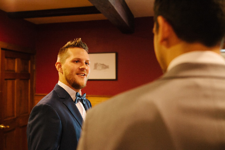 groom smiling and talking with friend at Chimney Hill Estate wedding in Lambertville