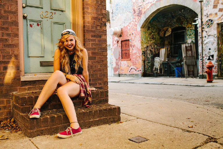 sitting on ledge outside Magic Garden South Street in Philadephia for senior photos by Kasey Ivan Photography