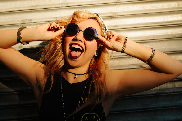 fun and unique shot of sunglasses and smile in downtown Philadelphia for senior photos by Kasey Ivan Photography