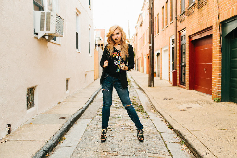 standing on cobblestone street in downtown Philadelphia for senior photos by Kasey Ivan Photography