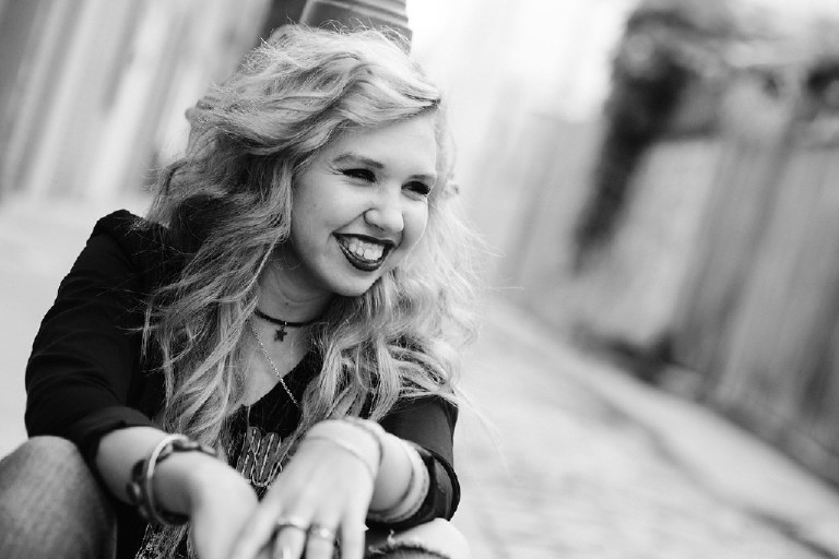 smiling and sitting rock star Kassi in downtown Philadelphia for senior photos by Kasey Ivan Photography