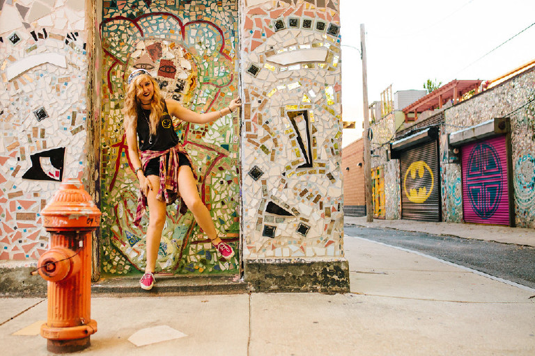 standing by batman door outside Magic Garden South Street in Philadephia for senior photos by Kasey Ivan Photography