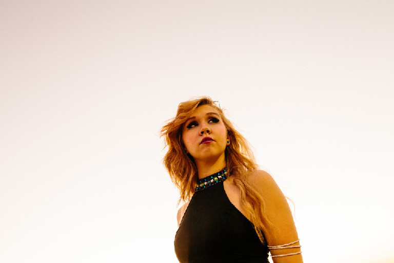 kassi looking out into the distance shot from below in downtown Philly for senior photos by Kasey Ivan Photography