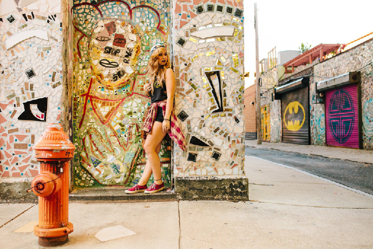 standing by batman door outside Magic Garden South Street in Philadephia for senior photos by Kasey Ivan Photography