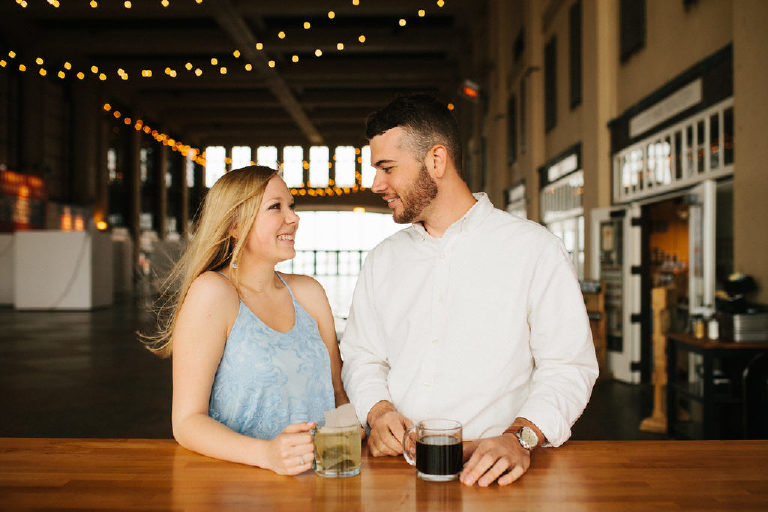 Smiling couple share a cup of coffee and tea at Asbury Park for engagement photos by Kasey Ivan Photography