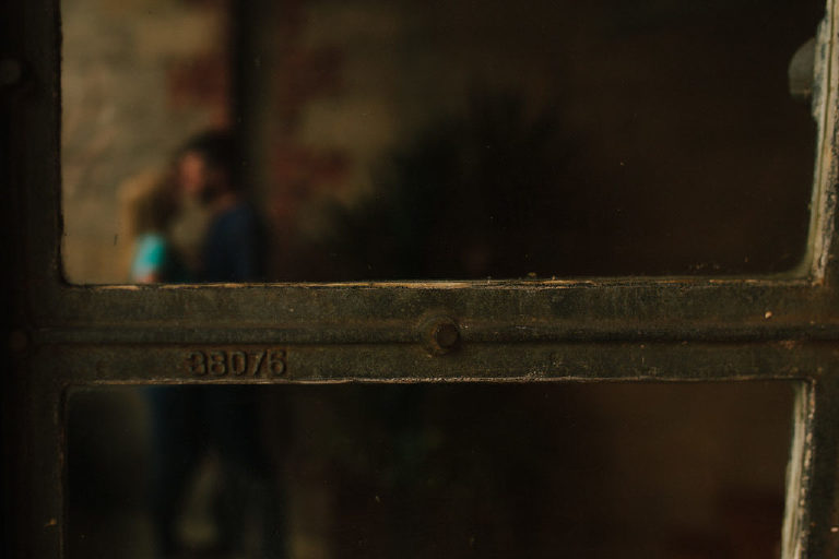 View of couple kissing through the rustic windows of Capitoline restaurant in Asbury Park NJ