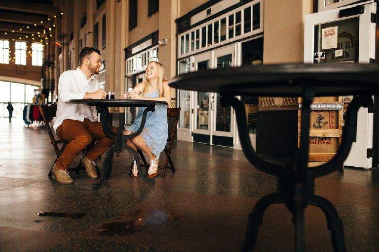 bride and groom sitting outside a coffee shop in Asbury Park Jersey Shore for their engagement photos by Kasey Ivan Photography