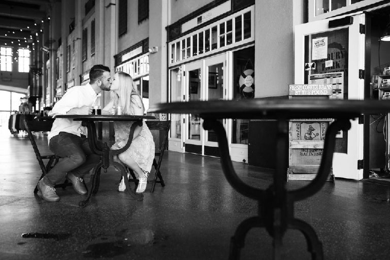 Black and white kiss at a Parisian cafe in Asbury Park for engagement photos by Kasey Ivan Photography