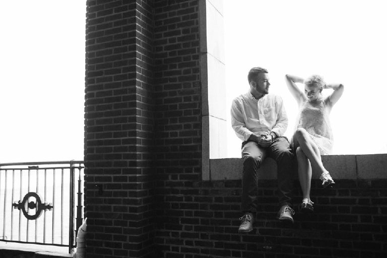 Jenna ties her hair while sitting with fiance on the ledge of the balcony overlooking the Jersey Shore