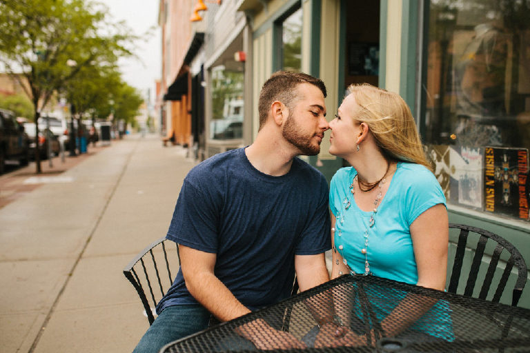 Couple leaning in for a kiss outside Twisted Coffee in Asbury Park NJ for engagement photos