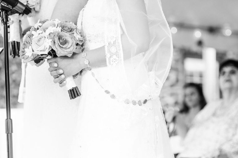 simple black and white photo of the veil and yugal of coins at a Pinoy wedding ceremony