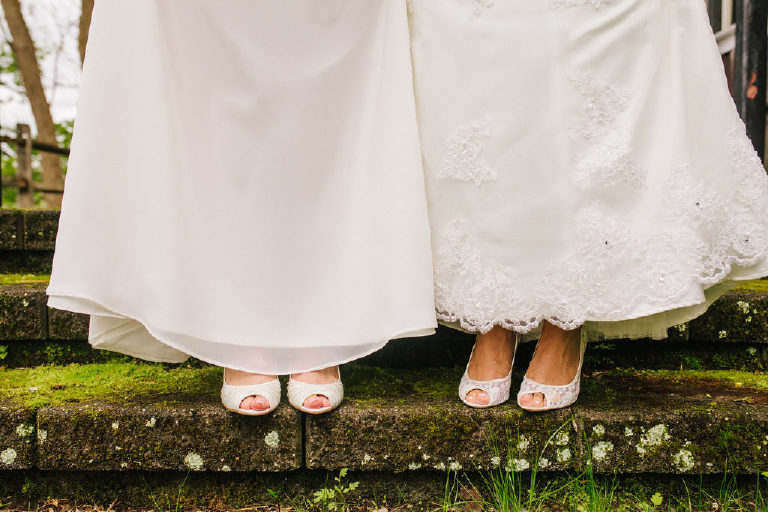 two brides two wedding dresses on mossy stone at 1740 House outside New Hope PA by Kasey Ivan Photography