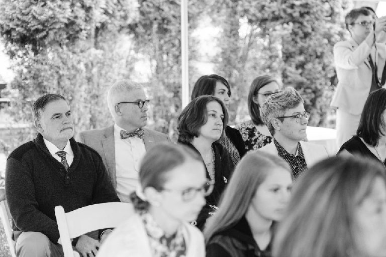guests look on as brides get married at an intimate rustic ceremony at the 1740 House