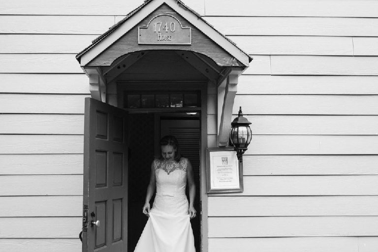 Bride exits front door of 1740 House in New Hope PA before wedding photography