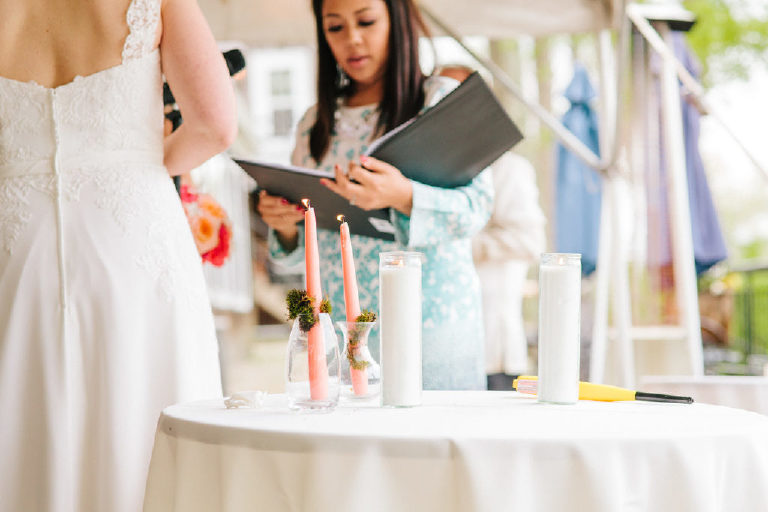 Filipina officiant reads through the wedding ceremony next to the unity candles
