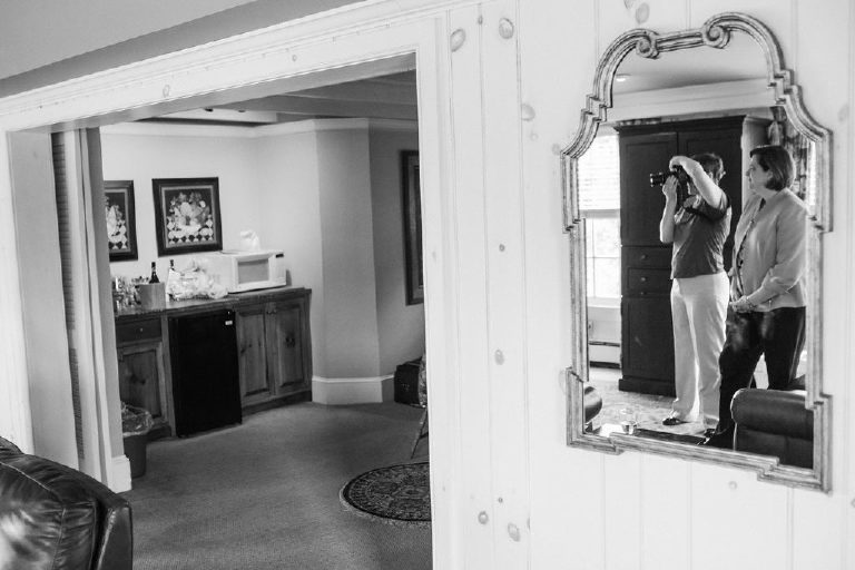 friends of the wedding couple take photos in an old mirror at the 1740 House