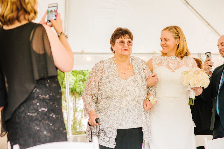 bride walks her mother down the aisle at an intimate same sex wedding ceremony
