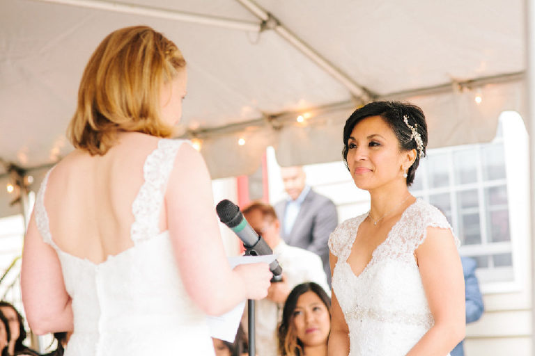 bright sunlit photo on patio overlooking the Delaware River as bride recites her vows at the 1740 House