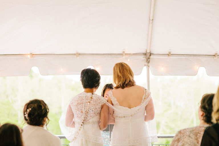 two young brides stand next to one another during a Filipino wedding ceremony outside 1740 House on the Delaware River