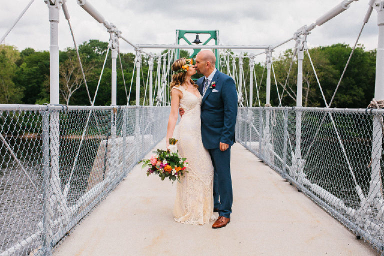 Bride and groom kiss while standing on the Lumberville foot bridge over the Delaware River outside the Black Bass Hotel by Kasey Ivan Photography