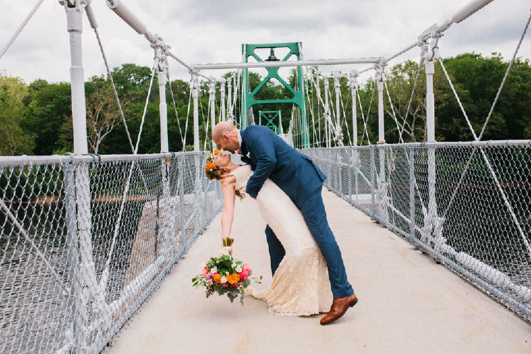 Bride and groom kiss while standing on the Lumberville foot bridge over the Delaware River outside the Black Bass Hotel by Kasey Ivan Photography