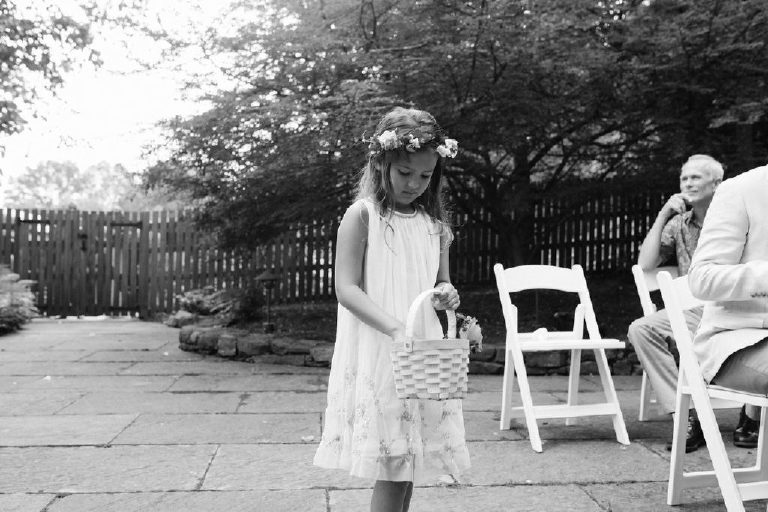 flower girl comes down the aisle of an intimate outdoor ceremony at the Black Bass Hotel