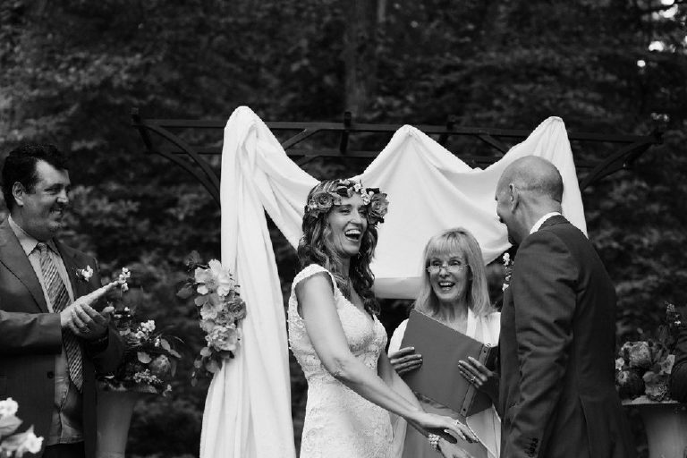 bride laughs after summer wedding ceremony in the woods at Black Bass Hotel outside New Hope Pennsylvania by Kasey Ivan Photography