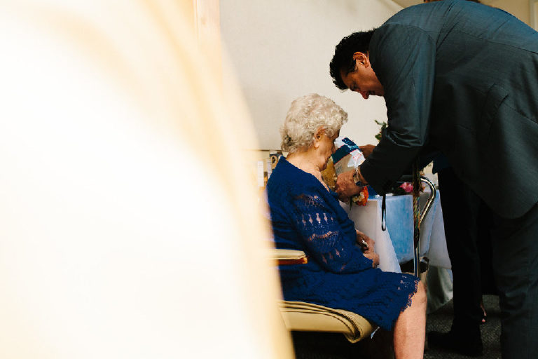 son pins a flower on the mother of the bride
