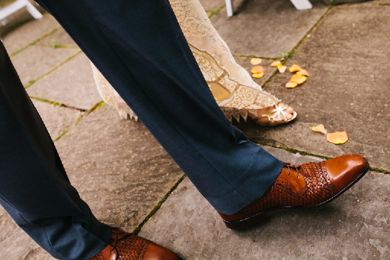 close up of bride and grooms feet walking to ceremony