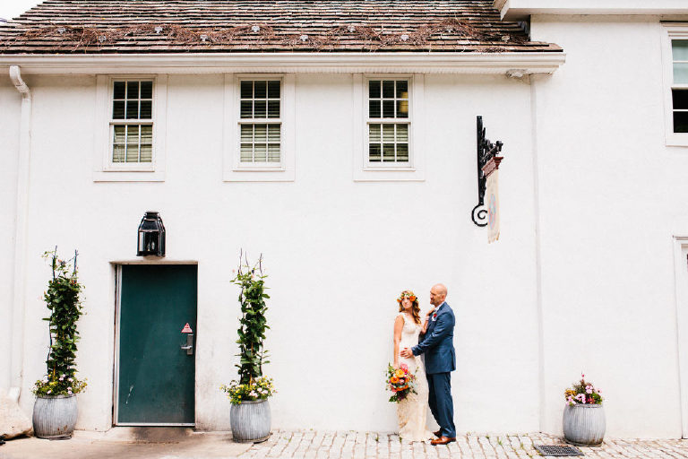 bride and groom pose for wedding photos outside the front of the Black Bass Hotel on River Road near New Hope PA by Kasey Ivan Photography