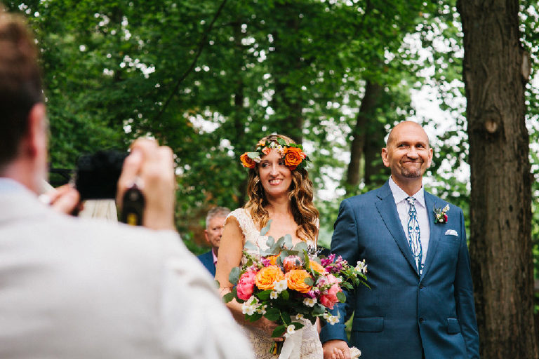 bride and groom walk down the aisle at summer wedding ceremony in the woods at Black Bass Hotel outside New Hope Pennsylvania by Kasey Ivan Photography