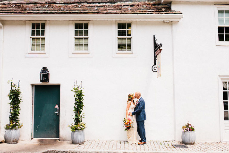 bride and groom pose for wedding photos outside the front of the Black Bass Hotel on River Road near New Hope PA by Kasey Ivan Photography