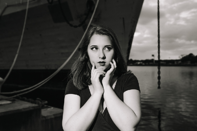 Black and white photograph of a Senior girl posing dramatically with her hands on her face for Kasey Ivan Photography