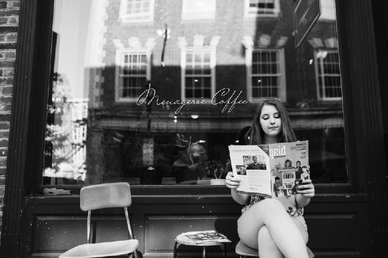 Senior girl sitting and reading a magazine infront of a coffee shop in old city Philadelphia