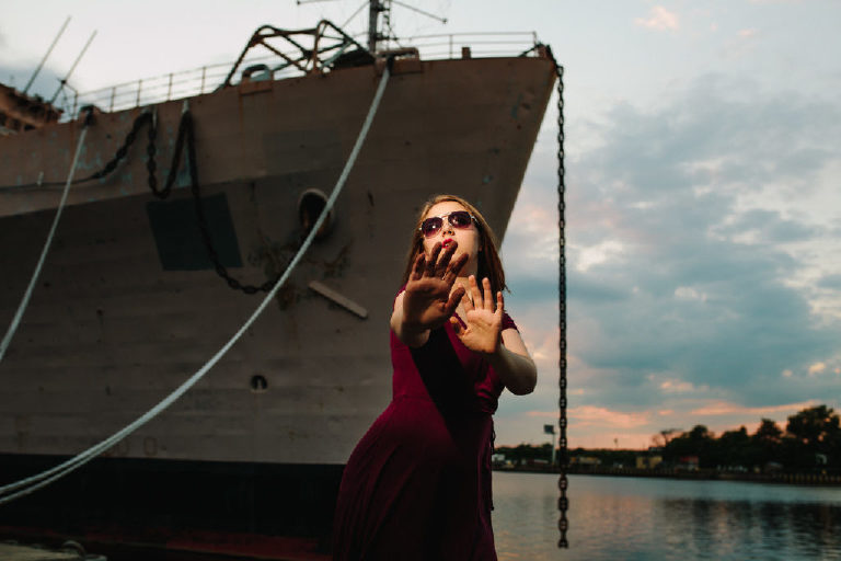 Girl trying to block paparazzi taking her picture wearing sunglasses posing for Kasey Ivan Photography