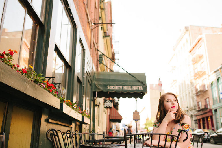 Senior girl sitting and thinking at a table outside of Society Hill Hotel in old city Philadelphia