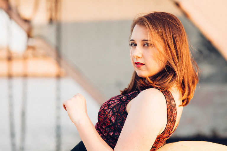 Senior girl leaning back and posing for Kasey Ivan Photography in the navy shipyard in Philadelphia for Kasey Ivan