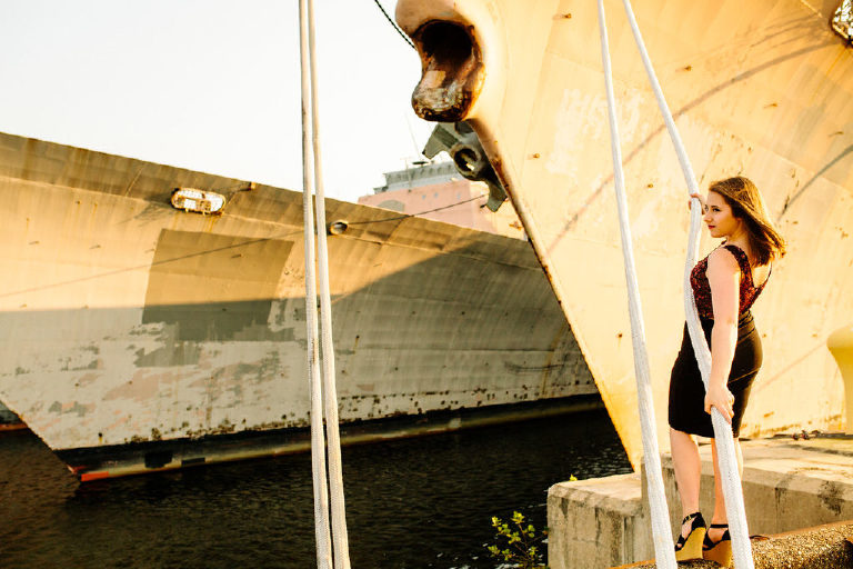 Senior girl leaning back holding onto rope at the navy shipyard in philadelphia posing for Kasey Ivan Photography