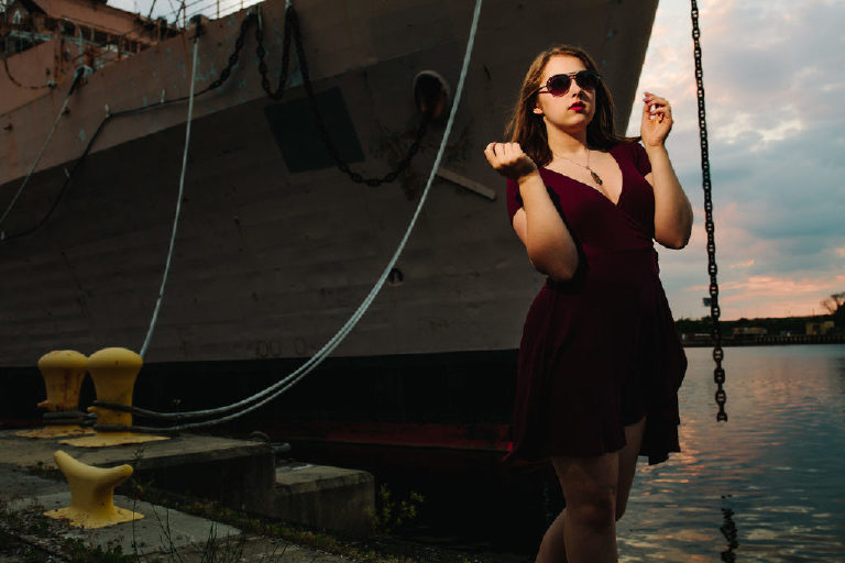 Senior girl posing strong and confident at the navy shipyard wearing sunglasses for Kasey Ivan Photography
